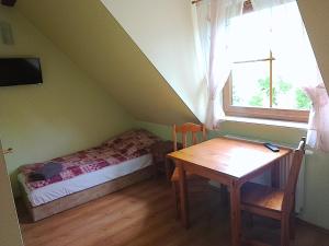 a bedroom with a bed and a table and a window at Zamkowa in Puck