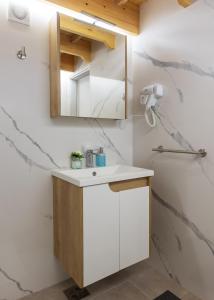 a bathroom with a white sink and a mirror at KING rooms in Bečej