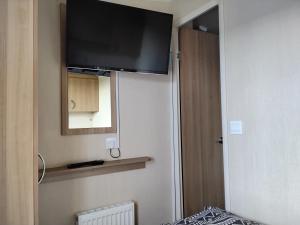 a television on the wall of a room with a bed at The Bay View in Eyemouth