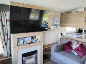 a living room with a flat screen tv above a fireplace at The Bay View in Eyemouth