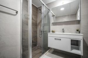 a bathroom with a white sink and a shower at Crystal by Solid Sea View Mamaia - Apartament langa plaja cu vedere la mare in Mamaia +5 photos