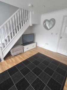 a living room with a staircase with a black rug at Highwood mews in Cleethorpes
