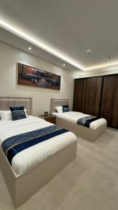 a hotel room with two beds and a painting on the wall at كلود فيو in Abha
