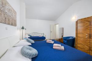 a bedroom with a blue bed with pillows on it at Funcic Apartments 1 app in Pula +20 photos