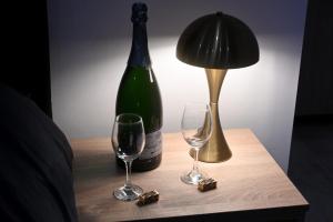 a bottle of wine and two wine glasses on a table at Elysium3 in Banja Luka