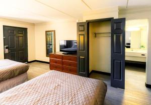 a bedroom with two beds and a flat screen tv at Home Suites Culebra in San Antonio