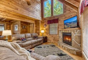 a living room with a couch and a fireplace at Bucky's Bungalow, Free Attraction Tickets, Hot Tub, WIFI!!! in Gatlinburg