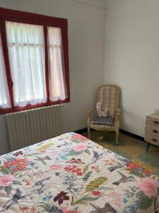 a bedroom with a bed and a chair and a window at Paul in Serra-di-Ferro