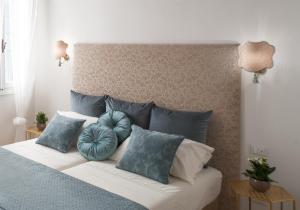 a bed with blue and white pillows on it at Ca del Mar Venice Luxury Apartments in Venice