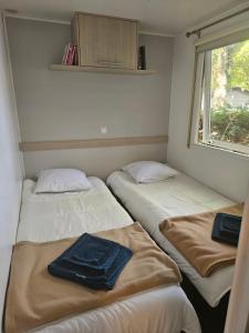 three beds in a small room with a window at Camping Mobil Home 6 Pers Rivage des Landes Piscine Landes in Aureilhan +25 photos