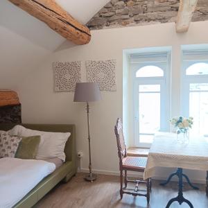 a bedroom with a bed and a table and two windows at Casa Belgeri in Dongio +139 photos