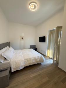 a bedroom with a bed and a flat screen tv at Tesorella guest house in Cassano dʼAdda