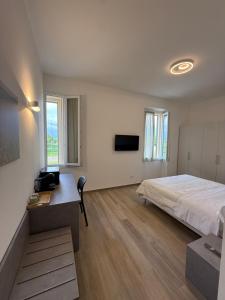 a bedroom with a bed and a desk and a tv at Tesorella guest house in Cassano dʼAdda