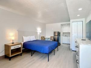 a bedroom with a blue bed and a kitchen at Stayable Davenport in Davenport