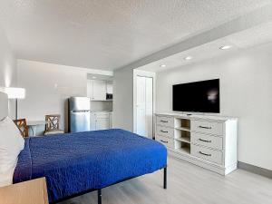a bedroom with a bed and a flat screen tv at Stayable Davenport in Davenport