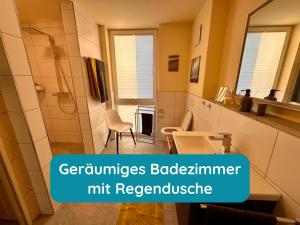 a bathroom with a shower and a sink and a mirror at Meerglück am Beltblick Fehmarn - FeWo mit Sauna, Blick auf Ostsee und Leuchtturm, nur 150 m zum Meer in Fehmarn