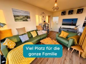 a living room with green couches and yellow pillows at Meerglück am Beltblick Fehmarn - FeWo mit Sauna, Blick auf Ostsee und Leuchtturm, nur 150 m zum Meer in Fehmarn