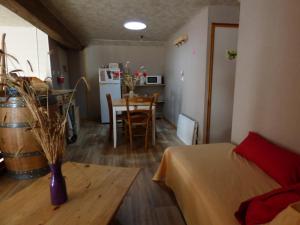a living room with a table and a room with a kitchen at Chambre bordeaux in La Roche-sur-Yon