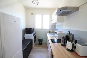 a small kitchen with a counter and a counter top at La Colline - Pont-Hébert - com - Grand Parking gratuit, De 1 à 4 personnes, Tout équipé, Netflix, Amazon Prime Gratuits et Illimités, Matelas Emma, Lave Linge, Vue sur la Vallée, RDC in Pont-Hébert