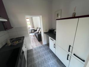 a kitchen with a white refrigerator and a living room at Gästewohnung Mable in Greiz +7 photos