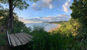 a bench sitting on a hill next to a beach at Casa Medusa in El Gigante +36 photos