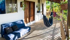 a blue couch sitting on a porch with a hammock at Casa Medusa in El Gigante