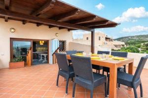 a patio with a wooden table and chairs at Casa Marina a 150mt dalla pelosa in Stintino