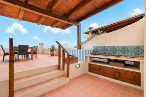 a patio with a table and chairs on a deck at Casa Marina a 150mt dalla pelosa in Stintino