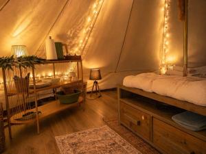 a bedroom with a bed and a desk with lights at Glamping auf dem Weberhof in Münster