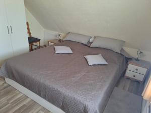 a bedroom with a large bed with two pillows on it at Haus Dorfschmiede, Wohnung Anker in Alkersum