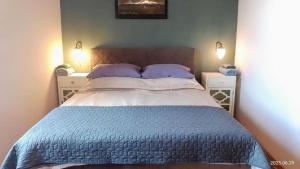 a bed in a bedroom with two night stands and two lamps at History Tornyos Apartman in Balatonfüred
