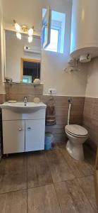 a bathroom with a toilet and a sink and a mirror at History Tornyos Apartman in Balatonfüred +6 photos