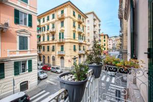 a balcony with two potted plants on a city street at Titi Rooms in La Spezia