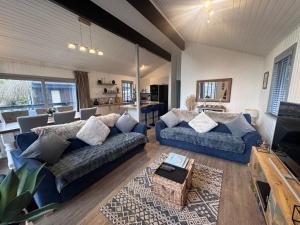 a living room with two blue couches and a table at Fig Tree Lodge in Ellonby