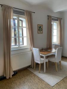 a dining room with a table and chairs and windows at Apartmán Na Pavlači in Velký Třebešov