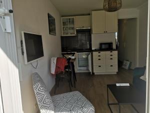 a small living room with a kitchen and a television at Escapade au Crouesty in Arzon