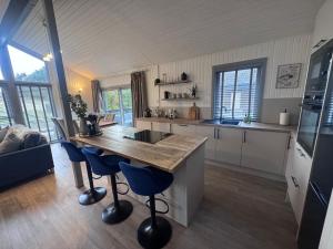 a kitchen with a wooden table and blue bar stools at Fig Tree Lodge in Ellonby +12 photos