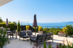 a patio with tables and chairs and an umbrella at Apartments Alba Chiara in Kastav