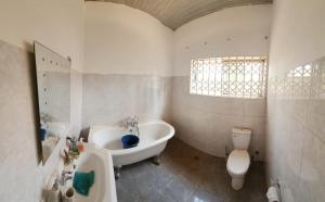 a bathroom with a tub and a sink and a toilet at S & J Lodge with high speed Starlink WiFi in Tamale +7 photos