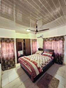 a bedroom with a bed and curtains and a ceiling at S & J Lodge with high speed Starlink WiFi in Tamale