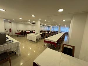 a dining room with white tables and chairs and tablesearcher at Hotel 13 de Outubro By Umbral in Fátima