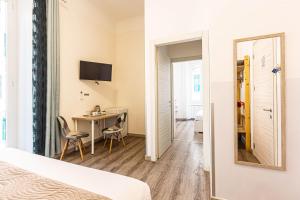 a bedroom with a bed and a desk and a mirror at Titi Rooms in La Spezia