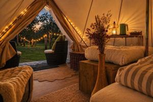 a room with a tent with a bed and a chair at Glamping auf dem Weberhof in Münster