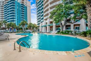 a swimming pool in the courtyard of a building with tall buildings at Legacy Tower I 302 in Gulfport