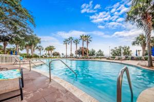 a swimming pool at a resort with palm trees at Legacy Tower II 107 Deluxe in Gulfport