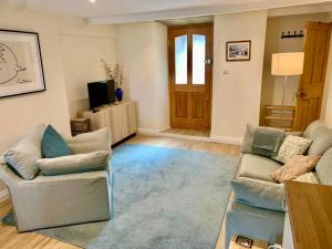 a living room with two couches and a television at Bobbin Cottage in Swanage