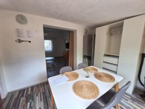 a kitchen and dining room with a white table and chairs at Bambusz76 in Zamárdi