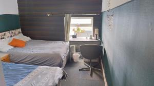 a bedroom with two beds and a desk and a sink at Havin B&B in Stoke on Trent