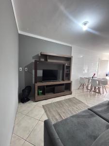 a living room with a couch and a television at Casa em itapema fácil acesso e bem localizada in Itapema