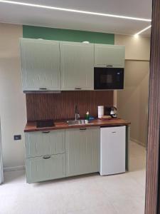 a kitchen with white cabinets and a sink and a microwave at Smarthome Boutique, Collegno in Collegno
